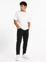 Jean skinny negro de corte ajustado, con elasticidad, bolsillos clásicos y cierre frontal con botón y cremallera.