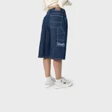 Bermuda baggy de denim azul oscuro con bolsillos cargo traseros y costuras a contratono.