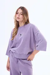 Buzo de felpa con cuello redondo a la base, de corte holgado y mangas tres cuartos con terminación desflecada. Presenta un acabado efecto lavado en color marrón.