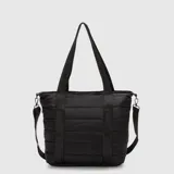 Bolso tipo tote color negro con diseño acolchado horizontal. Cuenta con doble asa de mano y una correa larga ajustable y extraíble, ambas con el logo de la marca estampado. Incluye cierre principal y compartimento interno protector para dispositivos electrónicos.
