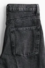 Jean tobillero estilo barrel de cinco bolsillos en denim de algodón rígido, con diseño curvo en las piernas y tiro alto.