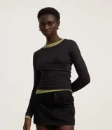 Blusa blanca de rib con cuello redondo y mangas largas.