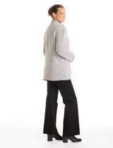 Cardigan de tejido de punto con diseño de espiga en color beige, totalmente forrado en corderito sintético blanco. Presenta cuello solapa, cierre frontal con botones, bolsillos tipo parche con solapa y terminaciones con vivos en contraste.