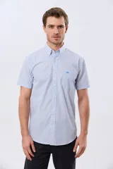 Camisa de manga corta a rayas celestes y blancas, con cuello abotonado, bolsillo frontal con logo bordado y cierre frontal de botones.