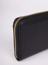 Billetera negra de símil cuero con cierre perimetral. Tiene dos compartimentos, espacio para ocho tarjetas, efectivo y un bolsillo con cierre para monedas.