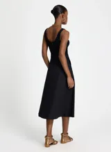 Vestido midi negro sin mangas, con corte evasé, cuello redondo y bolsillos laterales.