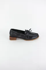 Mocasín náutico de cuero azul, con detalle de cordones en el empeine y taco cuadrado bajo simil madera.