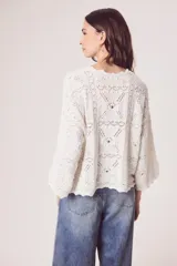 Sweater de tejido de punto calado color marrón, con diseño oversize, cuello redondo y mangas tres cuartos.