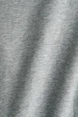 Campera canguro de felpa color gris, de corte holgado con hombros caídos, capucha forrada, cierre frontal y bolsillos tipo parche en la parte delantera. Presenta puños y dobladillo en punto acanalado.