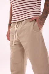 Pantalón de corte recto color beige con cintura ajustable con cordón.