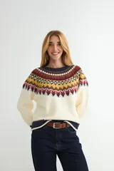 Buzo de punto con diseño de jacquard en el canesú, cuello redondo y mangas largas. Presenta un patrón geométrico multicolor en tonos crema, mostaza, bordó y azul marino sobre una base crema.