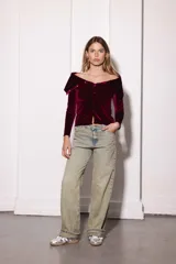 Remera color bordó de terciopelo con escote bardot y mangas largas.