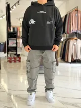 Canguro oversize gris con capucha y gran estampado gráfico trasero en tono más oscuro.