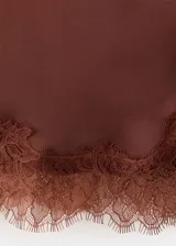 Falda midi recta de satén color marrón, con tiro regular y detalle de puntilla en el ruedo y el lateral.