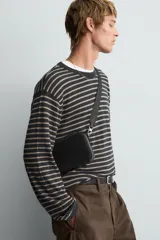 Bolso bandolera negro de cuero con correa ajustable y extraíble.