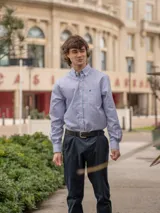 Camisa de corte clásico con estampado de cuadros en tonos rosados y celestes, con cuello abotonado, manga larga y bolsillo frontal con detalle bordado.