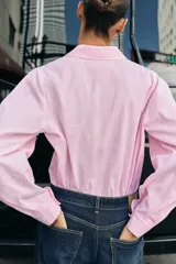 Camisa de algodón con estampado de rayas verticales en color rosado y blanco, cuello solapa y manga larga.