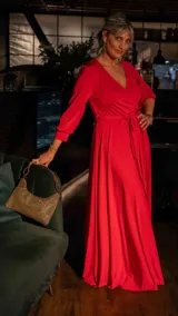 Vestido largo negro con escote en V cruzado, mangas largas y lazo en la cintura.