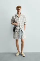 Camisa regular fit confeccionada en tejido de algodón con diseño de cuadros en tonos celestes y beige, cuello con botones, manga larga con puño abotonado y bolsillo de parche en el pecho.