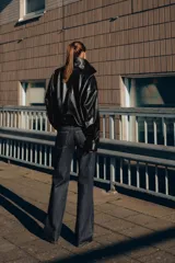 Chaqueta de efecto piel con cuello subido, manga larga con puños y bajo elástico. Presenta cierre frontal con cremallera y botones a presión ocultos, además de bolsillos laterales y forro interior.