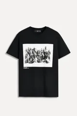 Remera negra de algodón con cuello redondo y mangas cortas. Estampado fotográfico en blanco y negro con texto Steven Meisel.