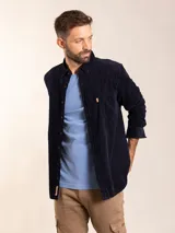 Camisa de manga larga azul marino de pana con cuello abotonado y bolsillo en el pecho.