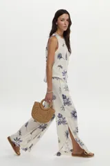 Pantalón de pierna ancha, confeccionado en lino, con cintura elástica con cordón de ajuste y estampado en tonos azules sobre base cruda.