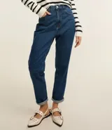 Pantalón mom jeans de tiro alto, color azul denim, con bolsillos delanteros y traseros, trabillas en la cintura y pespuntes contrastantes.