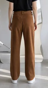 Pantalon de gamuza color marron, de corte recto y tiro medio, con cierre frontal y bolsillos laterales.