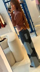 Jean de corte recto y tiro medio, confeccionado en denim con diseño de recortes geométricos en forma de rombos que generan un contraste de tonos entre negro y azul lavado.