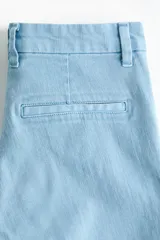 Jean acampanado de denim suave en color celeste, con tiro alto, cierre frontal con botón y bolsillos traseros.