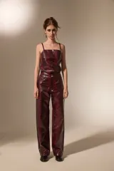 Pantalon de corte recto con diseño de estampado de piel de serpiente, confeccionado en cuero sintético (PU). Presenta bolsillos laterales y cierre frontal con botón.