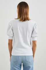 Remera blanca de algodón con mangas cortas abullonadas y cuello henley con tapeta de botones.