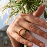 Anillo de plata 925 bañada en oro 18k con una piedra central de topacio azul rectangular y una esmeralda circular a cada lado.