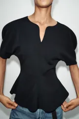 Camiseta negra de cuello redondo con escote en pico, manga corta abullonada y bajo con diseño peplum.