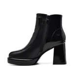 Botín de charol negro con plataforma y tacón cuadrado. Presenta una hebilla decorativa en el lateral exterior.