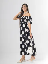 Vestido largo de lunares con escote bote y hombros descubiertos, mangas cortas abullonadas, cuerpo con nido de abeja y falda amplia.