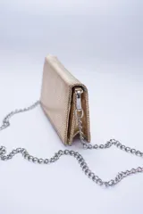 Cartera negra con textura símil cocodrilo y cadena metálica plateada.