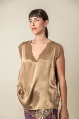 Blusa blanca de seda viscosa con escote en V y mangas cortas con detalle de gasa.