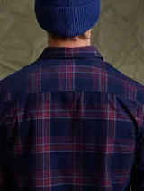 Camisa de pana color azul marino, con mangas largas, cuello clásico y dos bolsillos frontales con solapa y botón.