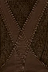 Overol de jean color marrón con calce barrel, tiro medio, pierna ancha y redondeada que termina a la altura del tobillo.