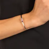 Pulsera rígida abierta de plata 925 con dos piedras engarzadas: una triangular de granate rojo y otra rectangular de cuarzo rosa.