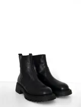 Bota corta de cuero negro con suela track dentada y cierre lateral externo.