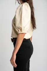 Remera de algodón negro con mangas cortas abullonadas, cuello redondo y costura central frontal.