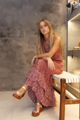 Vestido largo de crochet con diseño de red, en tonos rojizos y blancos. Presenta un corte sin mangas y una falda con volados en la parte inferior.