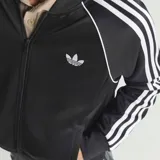 Campera deportiva Adidas Originals color negro, con cierre frontal, cuello alto, puños y cintura acanalados. Presenta las icónicas tres tiras blancas en las mangas y el logo del trébol bordado en el pecho.
