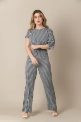 Mono largo a rayas verticales blancas y negras con mangas cortas asimétricas y cierre invisible en la espalda.