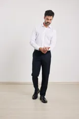 Pantalón de vestir azul marino, de corte recto, con bolsillos laterales y traseros. Se ajusta a la cintura con cinturón de cuero negro.