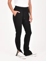 Pantalón negro de corte recto, con cintura elástica y cordón ajustable. Incluye bolsillos laterales y cierres en los tobillos.
