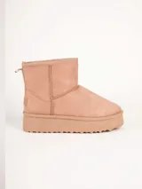 Botas cortas estilo UGG de gamuza color tostado, con plataforma alta y suela dentada.